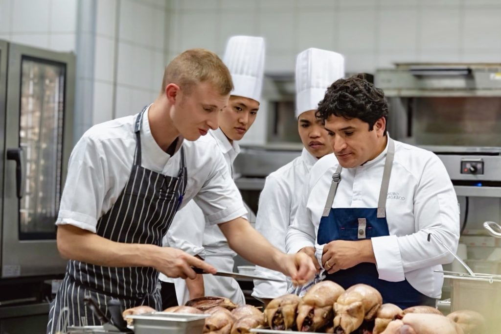 Chef Mauro Colagreco en cuisine, secondé par son chef en second et sa brigade